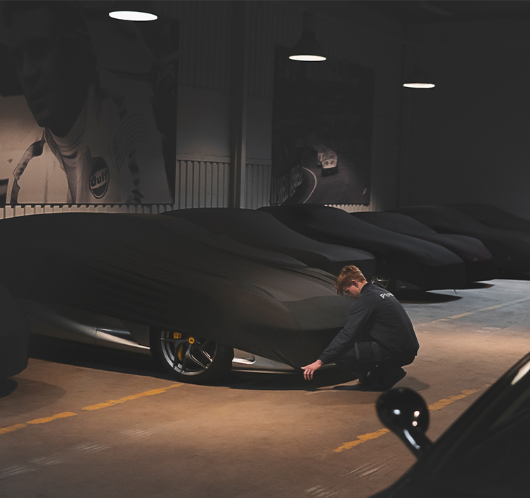 Een auto wordt zorgvuldig afgedekt in het Prins Autohotel